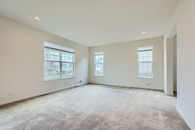 carpeted spare room featuring recessed lighting, visible vents, and baseboards