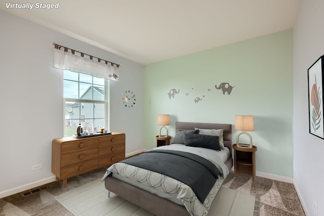 carpeted bedroom with visible vents and baseboards