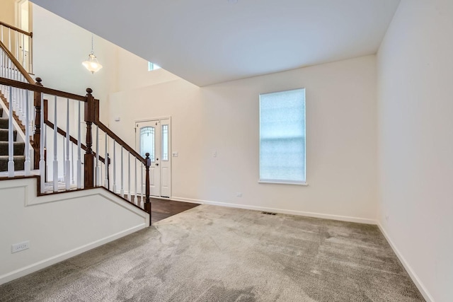 interior space with stairs, visible vents, baseboards, and carpet floors