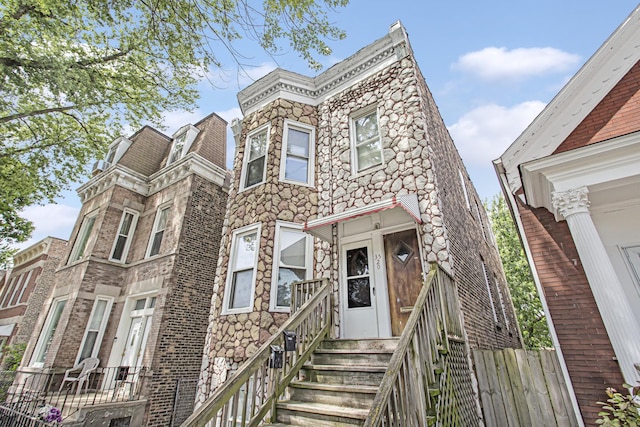 view of front facade featuring fence and stone siding