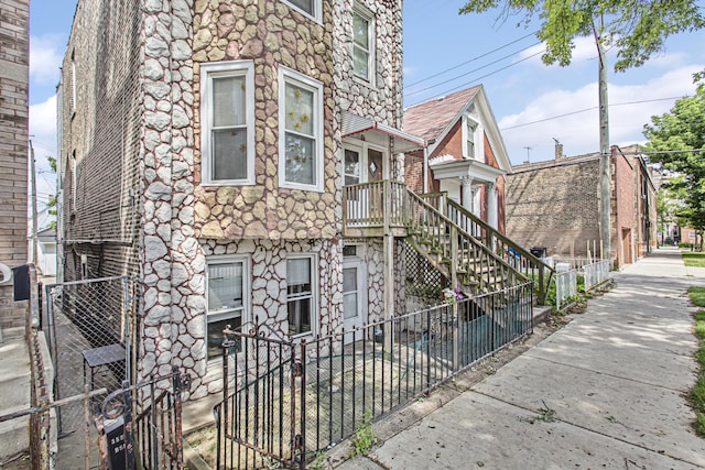 view of front of home featuring fence and stone siding