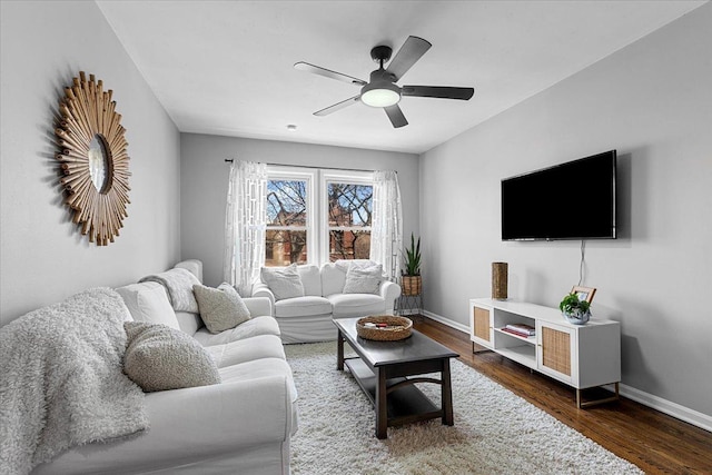 living room featuring wood finished floors, baseboards, and ceiling fan