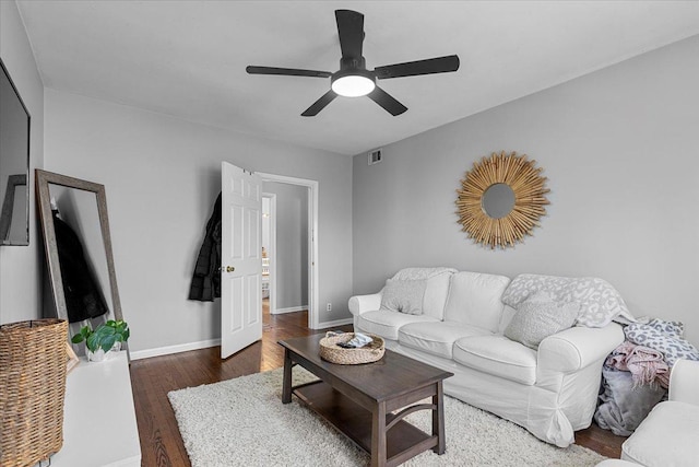 living room featuring visible vents, ceiling fan, baseboards, and wood finished floors