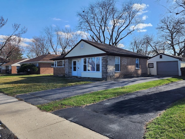 view of front facade featuring a front yard, driveway, an outdoor structure, a detached garage, and brick siding