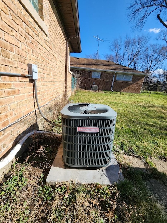 details with brick siding, central air condition unit, and fence