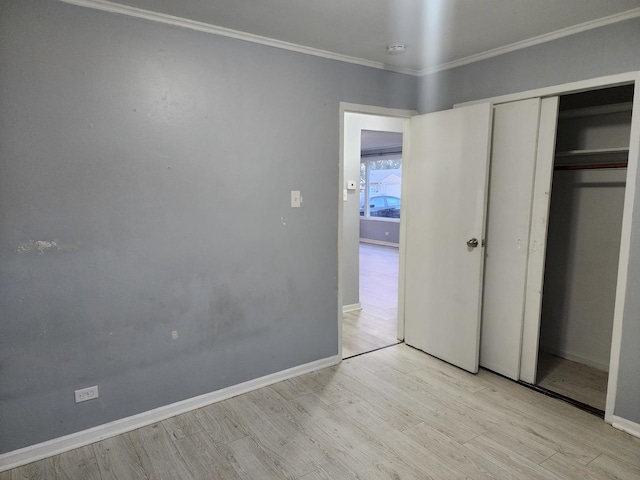 unfurnished bedroom with light wood finished floors, a closet, baseboards, and ornamental molding