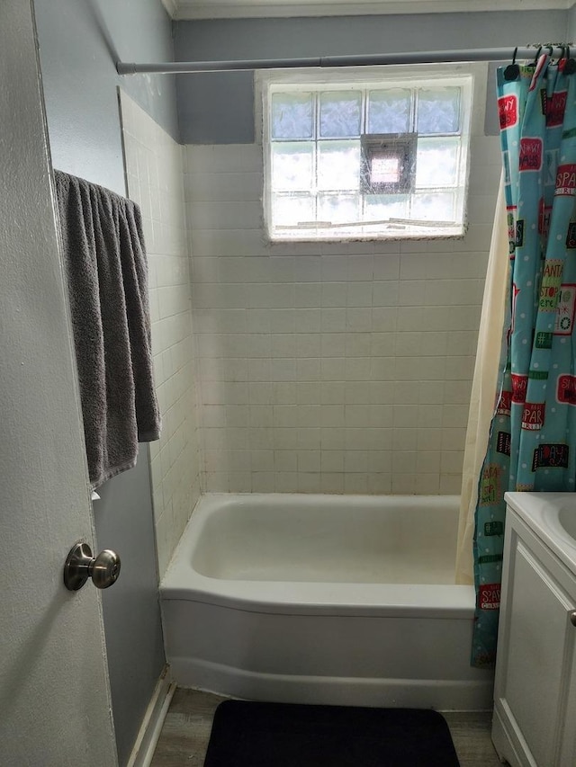 full bath featuring baseboards, shower / tub combo with curtain, wood finished floors, and vanity