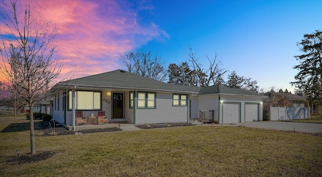 view of front of home featuring a lawn, a porch, fence, concrete driveway, and an attached garage