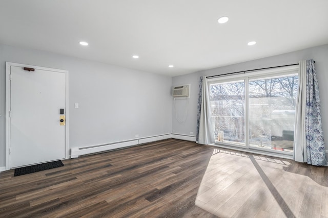 spare room with dark wood finished floors, baseboard heating, recessed lighting, and a wall mounted AC