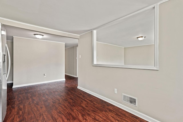 spare room featuring visible vents, baseboards, wood finished floors, and ornamental molding