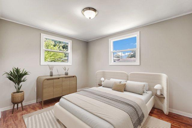 bedroom with baseboards, wood finished floors, and ornamental molding