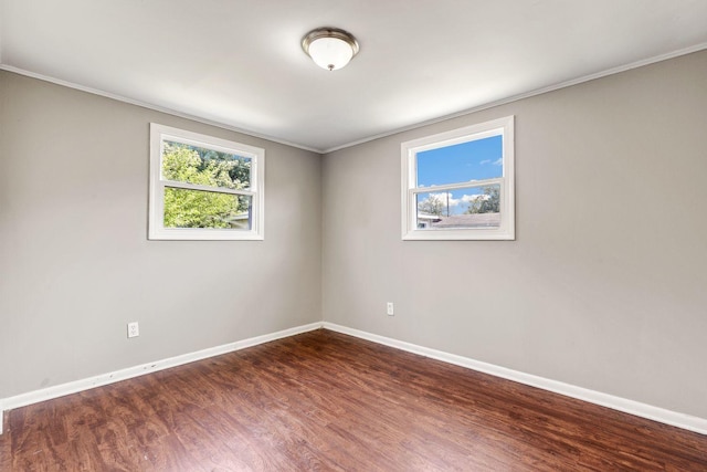 unfurnished room featuring ornamental molding, baseboards, and wood finished floors