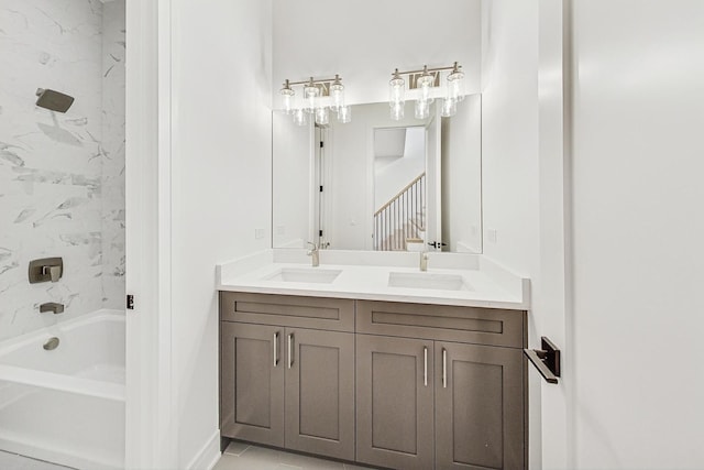 bathroom with double vanity, bathtub / shower combination, and a sink