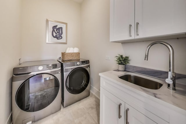 washroom featuring a sink, cabinet space, washing machine and dryer, and light tile patterned floors