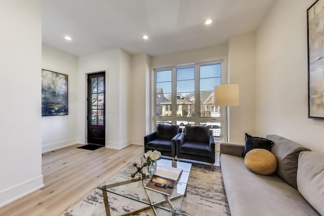 living room with recessed lighting, light wood-type flooring, baseboards, and visible vents