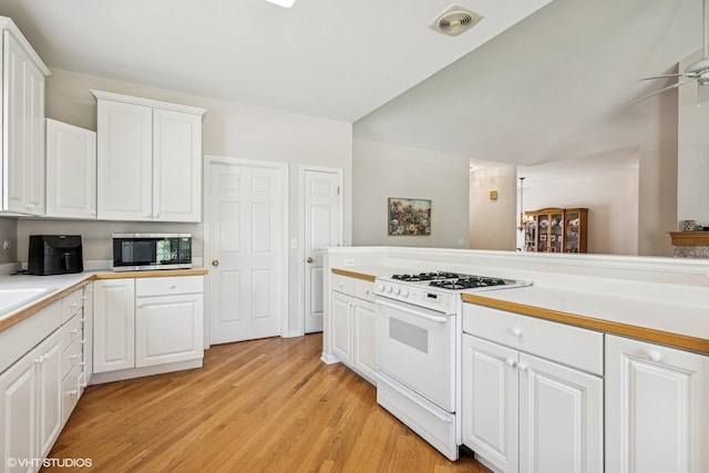 731 Norwich Ct, Crystal Lake, IL 60012 - kitchen with gas range gas stove, stainless steel microwave, a ceiling fan, light countertops, and vaulted ceiling