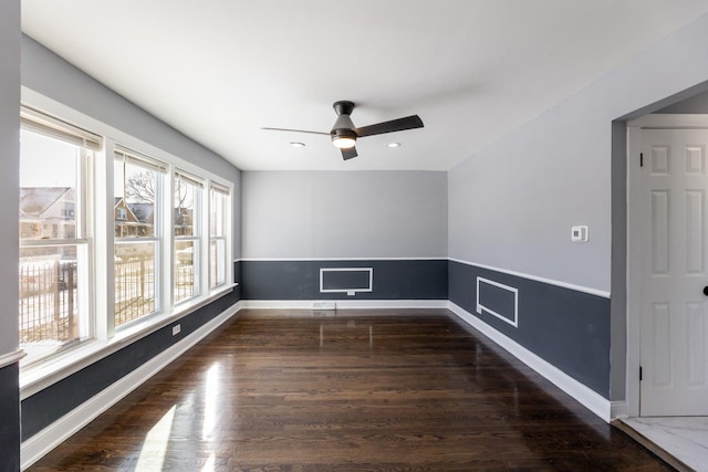 empty room with a ceiling fan, wood finished floors, and baseboards