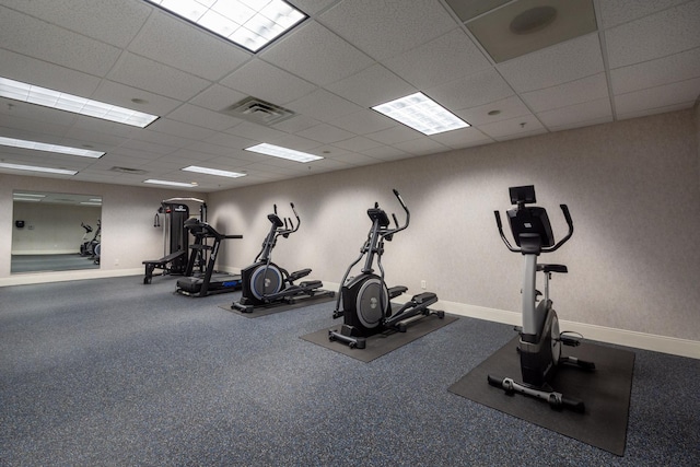 exercise room with a drop ceiling, baseboards, and visible vents