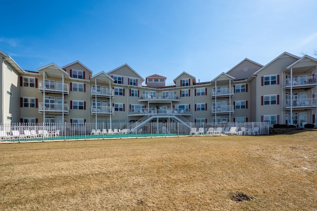 view of property's community featuring a lawn and fence