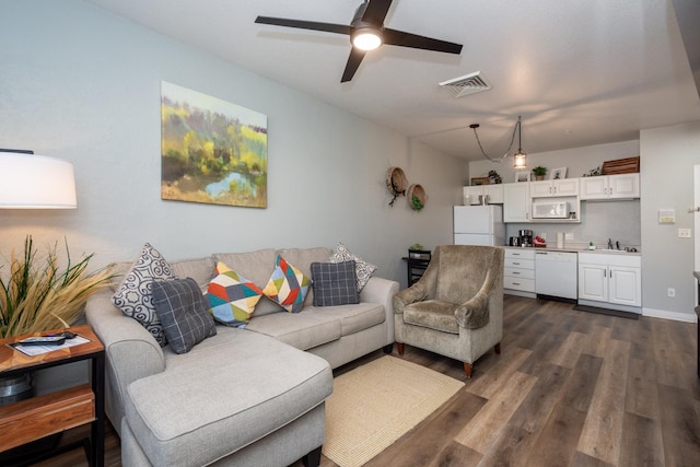 living room with dark wood finished floors, visible vents, and ceiling fan