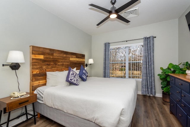 bedroom featuring dark wood finished floors, baseboards, visible vents, and a ceiling fan