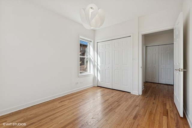 unfurnished bedroom featuring a closet, baseboards, and light wood-style floors