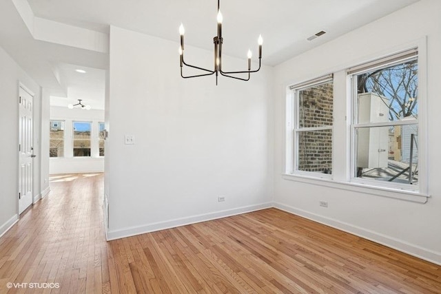 unfurnished dining area featuring light wood-style floors, visible vents, a wealth of natural light, and baseboards