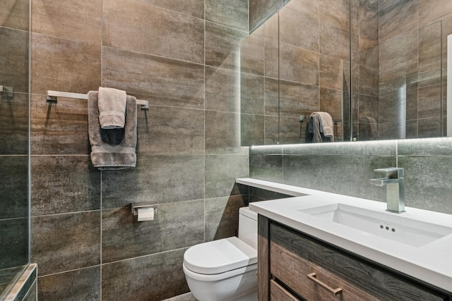 bathroom with vanity, tile walls, toilet, and decorative backsplash