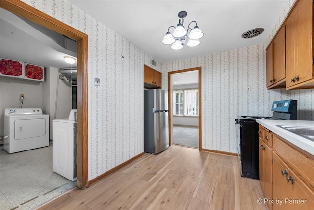 kitchen with wallpapered walls, separate washer and dryer, and appliances with stainless steel finishes