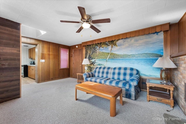 living room with light carpet, wooden walls, and ceiling fan