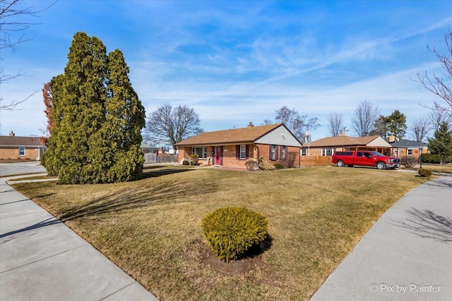 ranch-style house with brick siding, a front yard, and fence