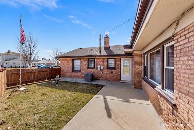 exterior space with a patio, cooling unit, fence, a chimney, and brick siding