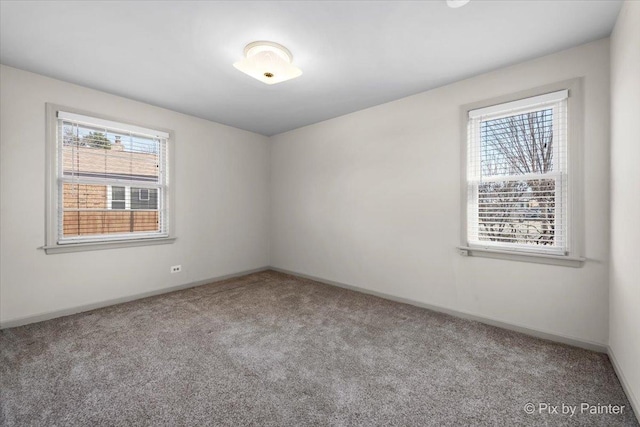 unfurnished room featuring carpet and baseboards