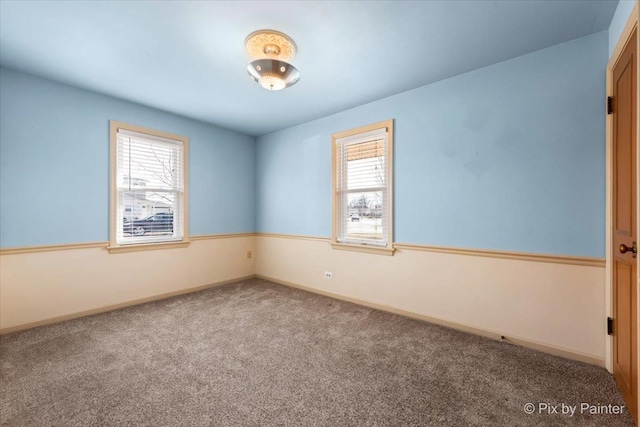 unfurnished room with carpet flooring and baseboards