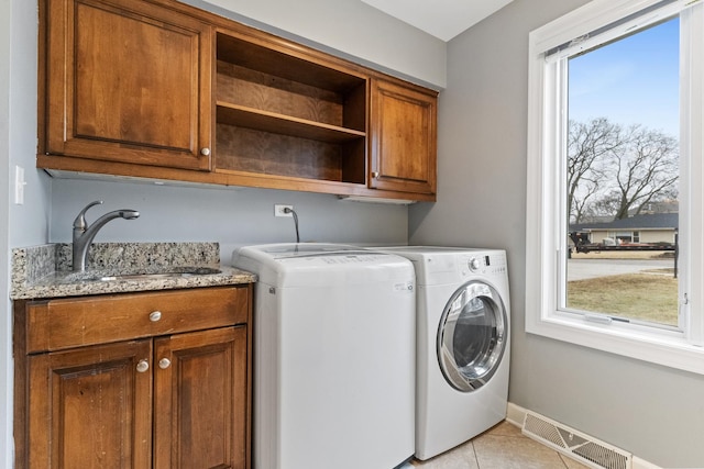 washroom featuring a sink, visible vents, cabinet space, and a wealth of natural light