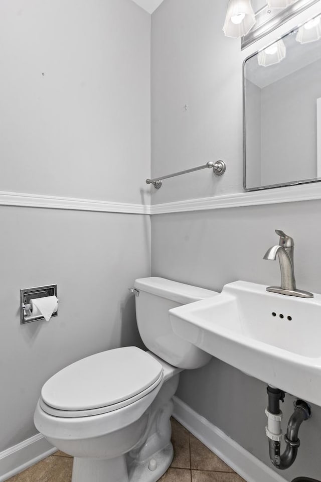 bathroom with tile patterned floors, baseboards, and toilet