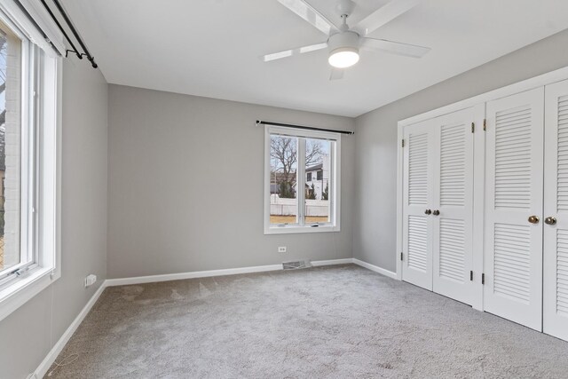 unfurnished bedroom with visible vents, ceiling fan, baseboards, and carpet