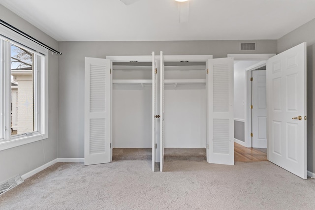 unfurnished bedroom featuring carpet, visible vents, two closets, and baseboards