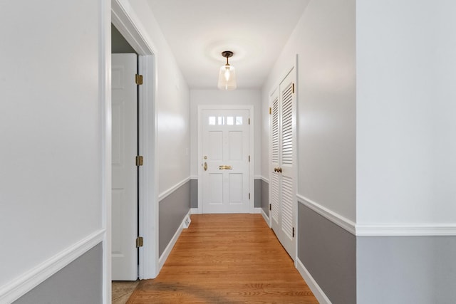 doorway to outside with light wood-style flooring and baseboards