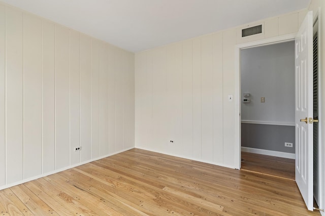 spare room with light wood-style floors and visible vents