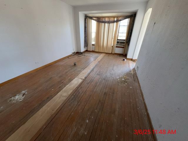 unfurnished room featuring baseboards and hardwood / wood-style flooring