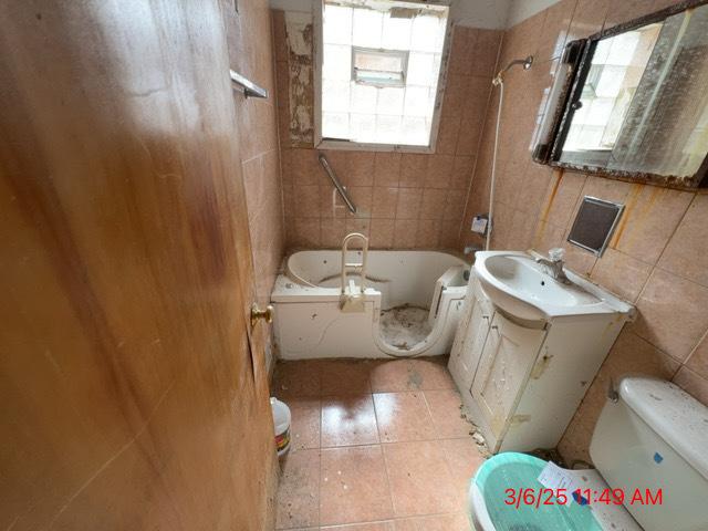 full bath with shower / washtub combination, vanity, toilet, and tile walls