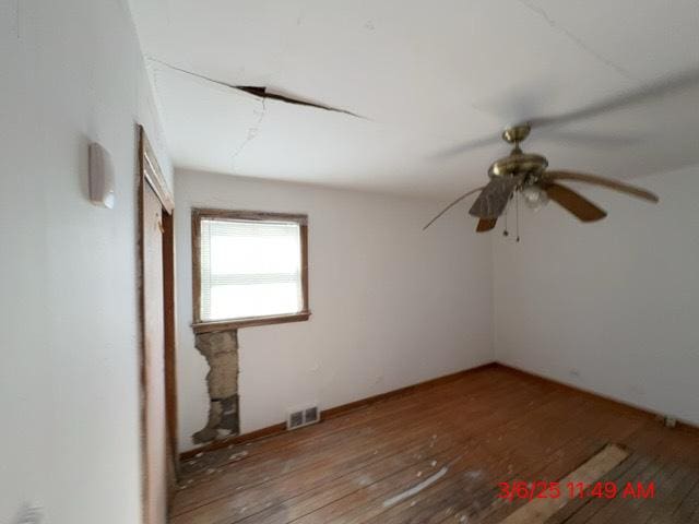 spare room featuring visible vents, hardwood / wood-style floors, and a ceiling fan