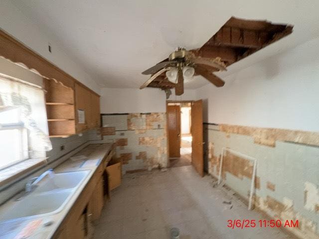 kitchen featuring brown cabinetry, open shelves, ceiling fan, a sink, and light countertops