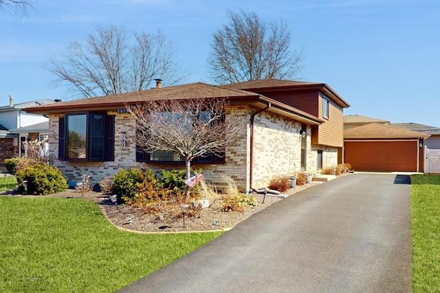 view of front facade featuring a garage, brick siding, and a front lawn