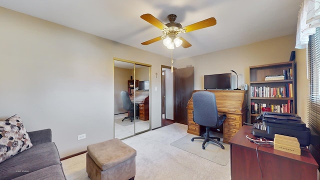 carpeted home office featuring ceiling fan