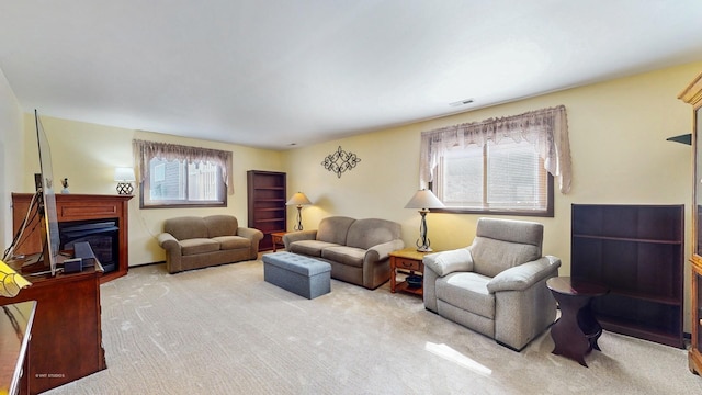 carpeted living area with a glass covered fireplace