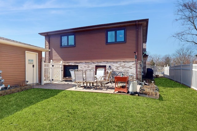 rear view of property with a fenced backyard, a lawn, and a patio