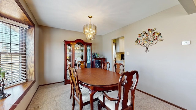 dining room featuring an inviting chandelier, light colored carpet, and a healthy amount of sunlight