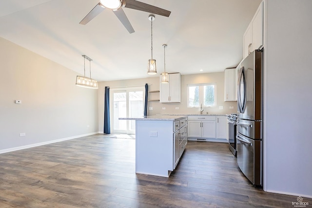 kitchen with baseboards, dark wood-type flooring, appliances with stainless steel finishes, white cabinetry, and a center island